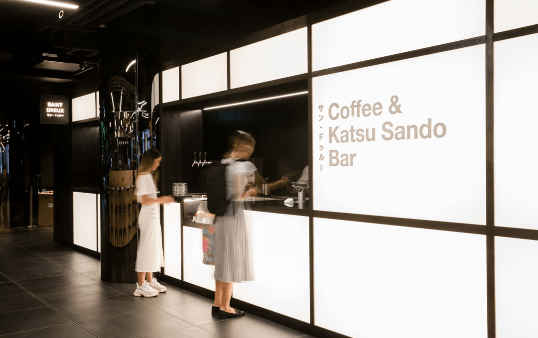 A futuristic facade with two people ordering at one of the best cafes in Melbourne.