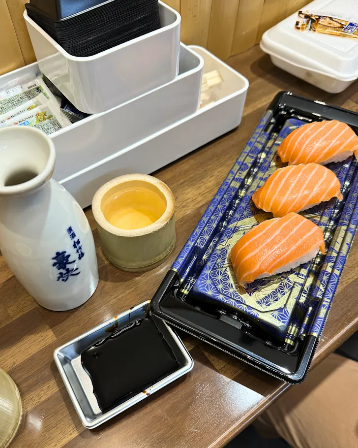 A plate of vibrant salmon sushi served with sake in Dotonbori Osaka.