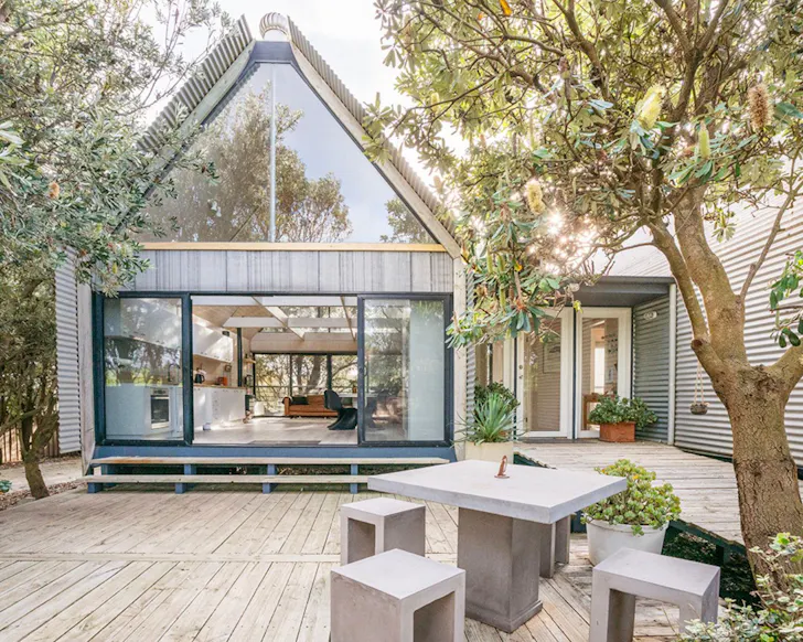 A view of the outdoor space and pointy roofed home at SaltHouse one of the best pet-friendly beach house Airbnbs Victoria