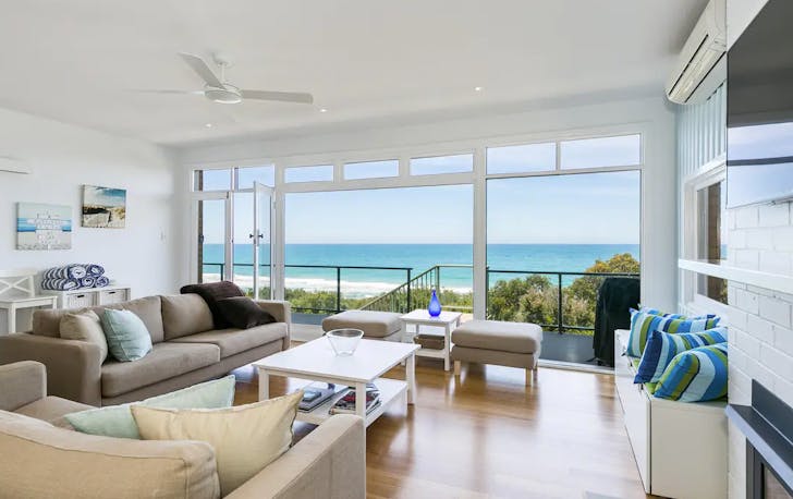 A living room with couches looking onto the ocean, a best Lorne accommodation option. 
