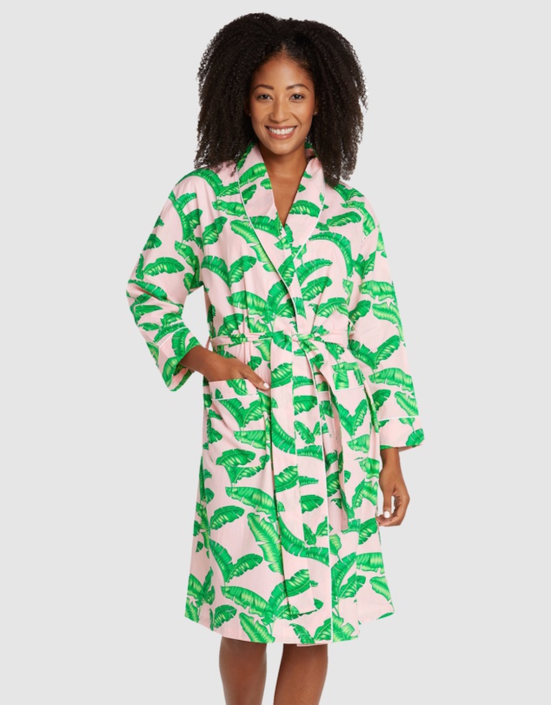 A woman smiles wearing a dressing gown with a palm tree print.