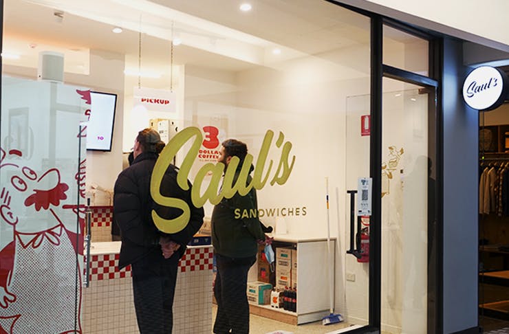 The shop front of Sauls with white paint and a gold Saul's logo on it