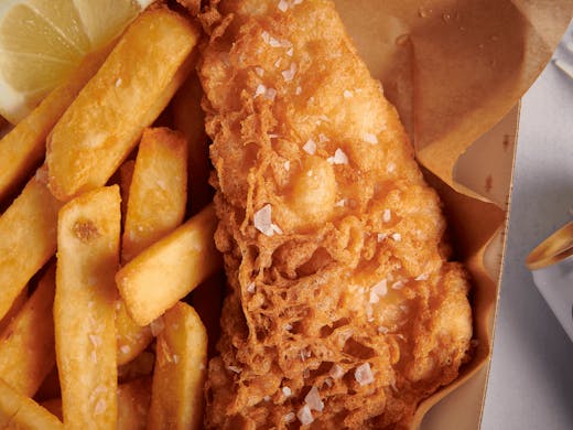 A box of fried fish and chips. 