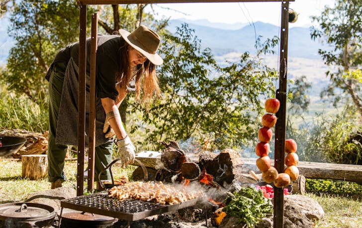 Woman cooking over a campfire