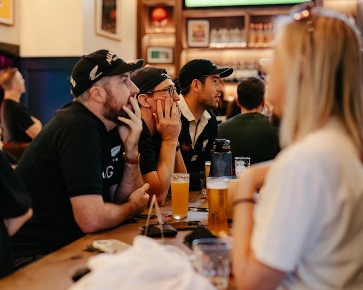 Sport fans watch a rugby game intently. 