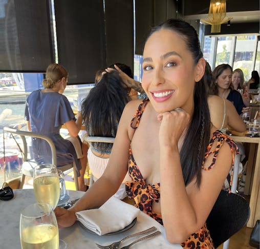 Woman sitting at a long lunch with wine.