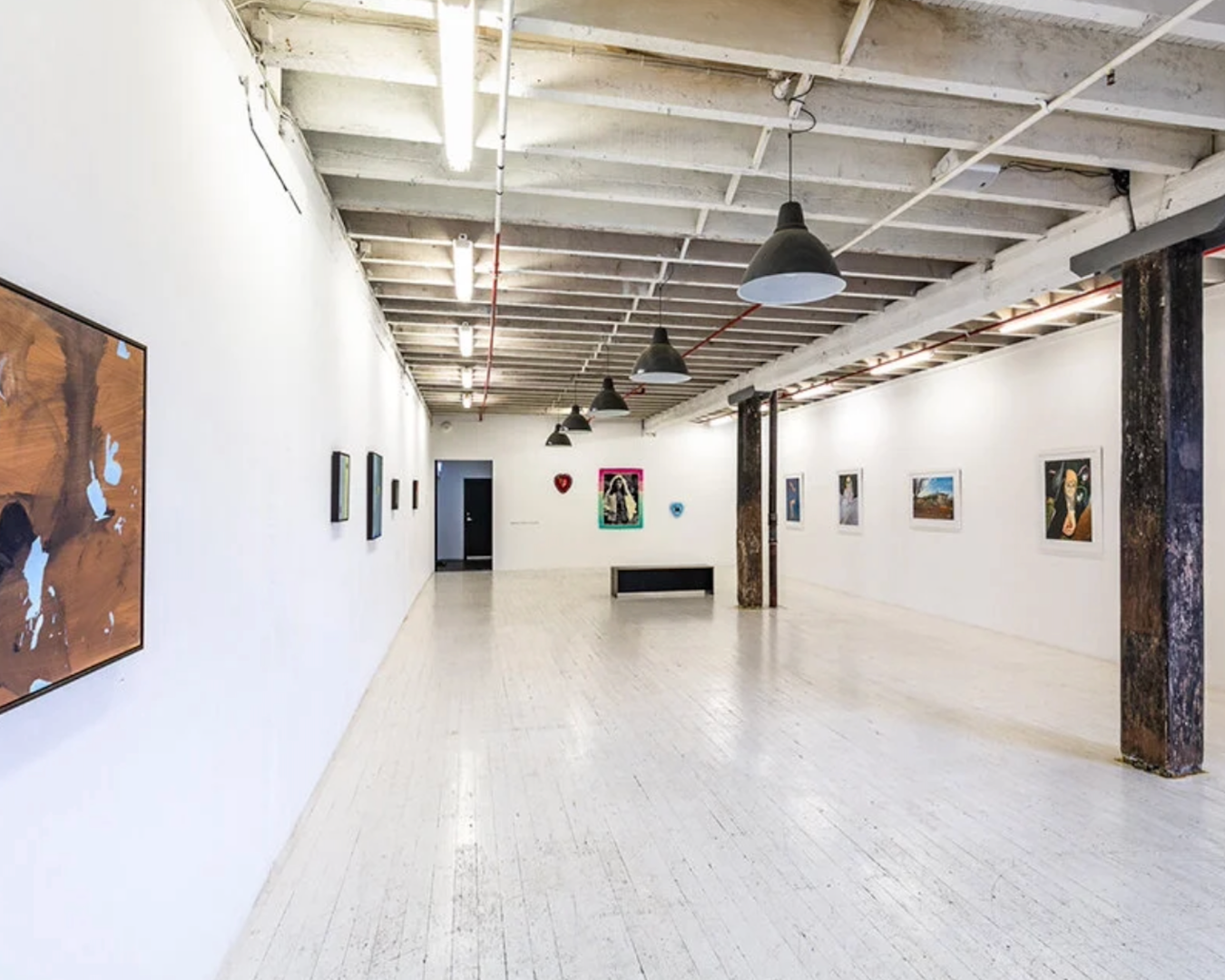Wide shot of the interior of China Heights Gallery, showcasing artworks spaced out along white, plain walls in a contemporary style.