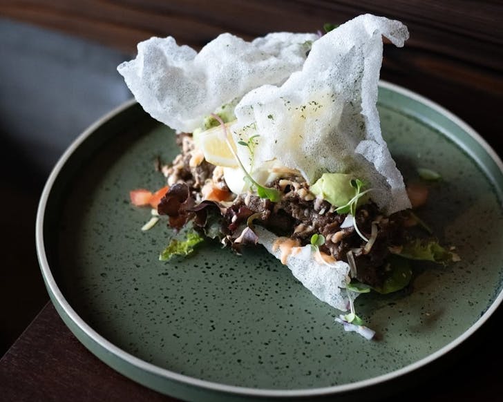 A crispy rice paper shell filled with lettuce, mashed avocado, cheese, sour cream and bulgogi beef.