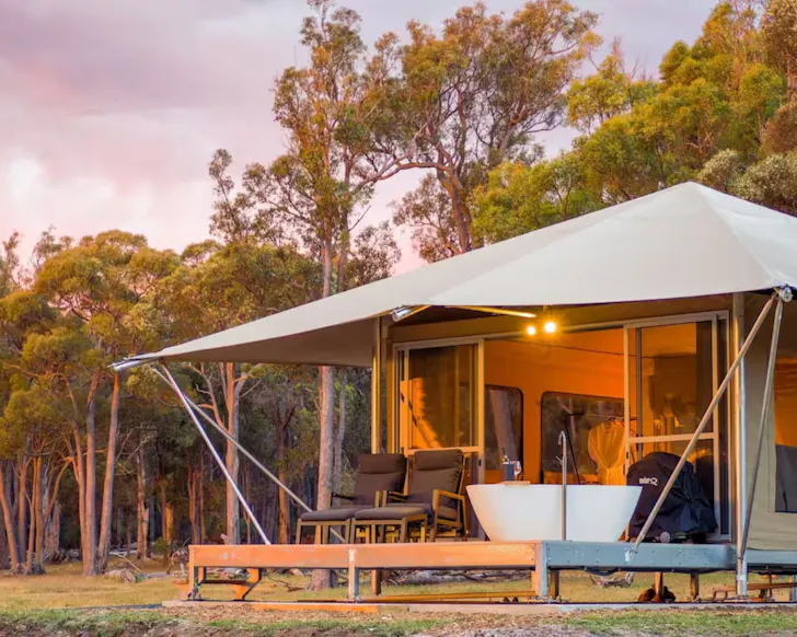 A glamping tent with a bathtub on the deck at Serenity Gully one of the best romantic getaways in Australia