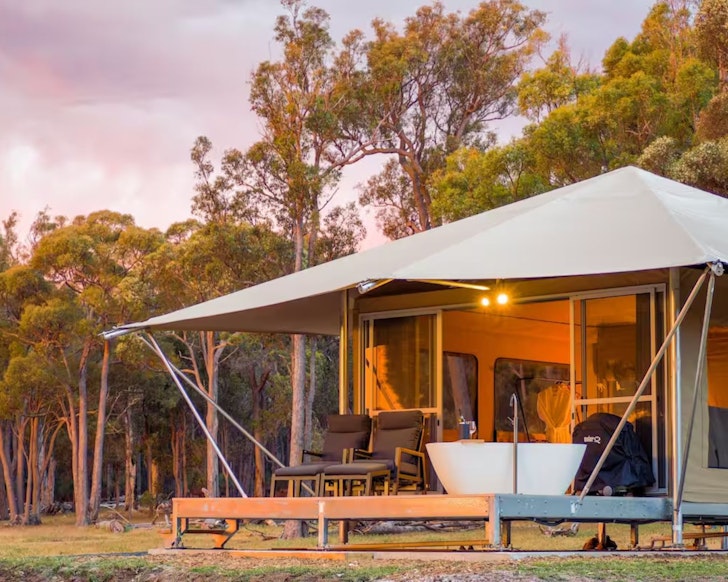 A glamping tent with a bathtub on the deck at Serenity Gully one of the best romantic getaways in Australia