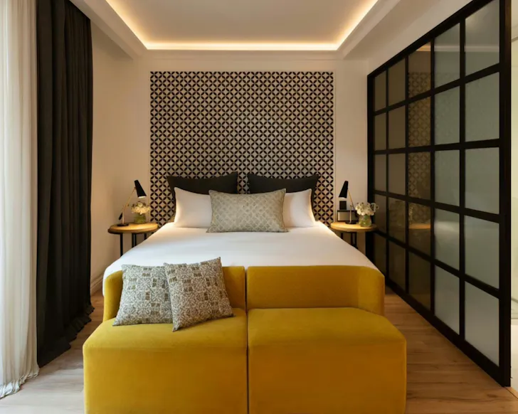 A bedroom at Serras Barcelona with a monochrome headboard.