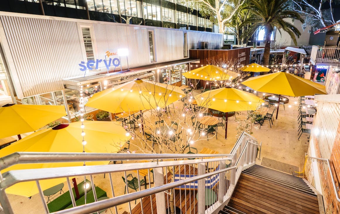 yard bar with festoon lighting and yellow umbrellas