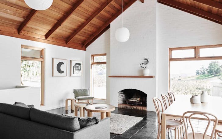 A white-brick lounge room with a fireplace, a winery accommodation Victoria. 