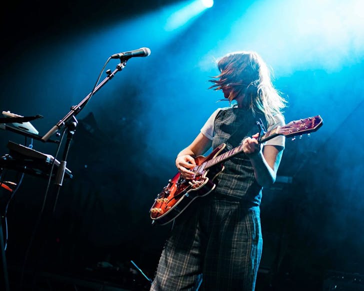 Sharon Van Etten & The Attachment Theory rock out on a blue-lighted stage.