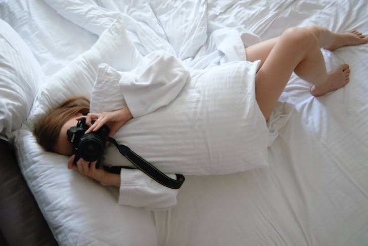 person laying in bed taking a photo