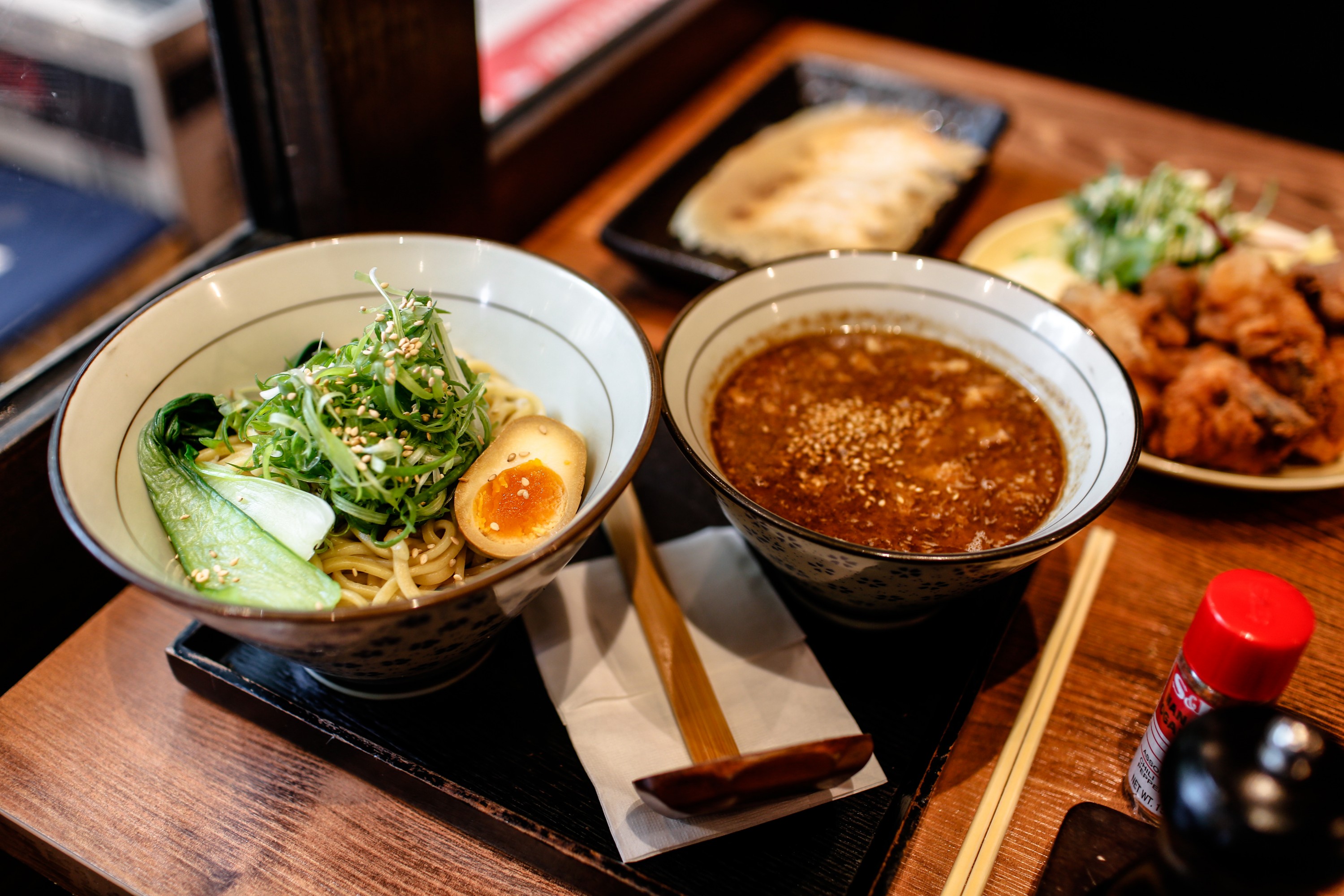 Two bowls of ramen inside a Melbourne Japanese restaurant with half-cut eggs.