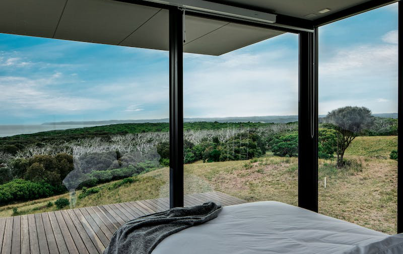 A bed looking out onto the coast at one of the best airbnbs in Victoria