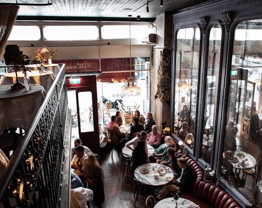 A busy diner looking down from a balcony seating area.