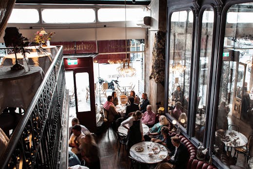 A busy diner looking down from a balcony seating area.