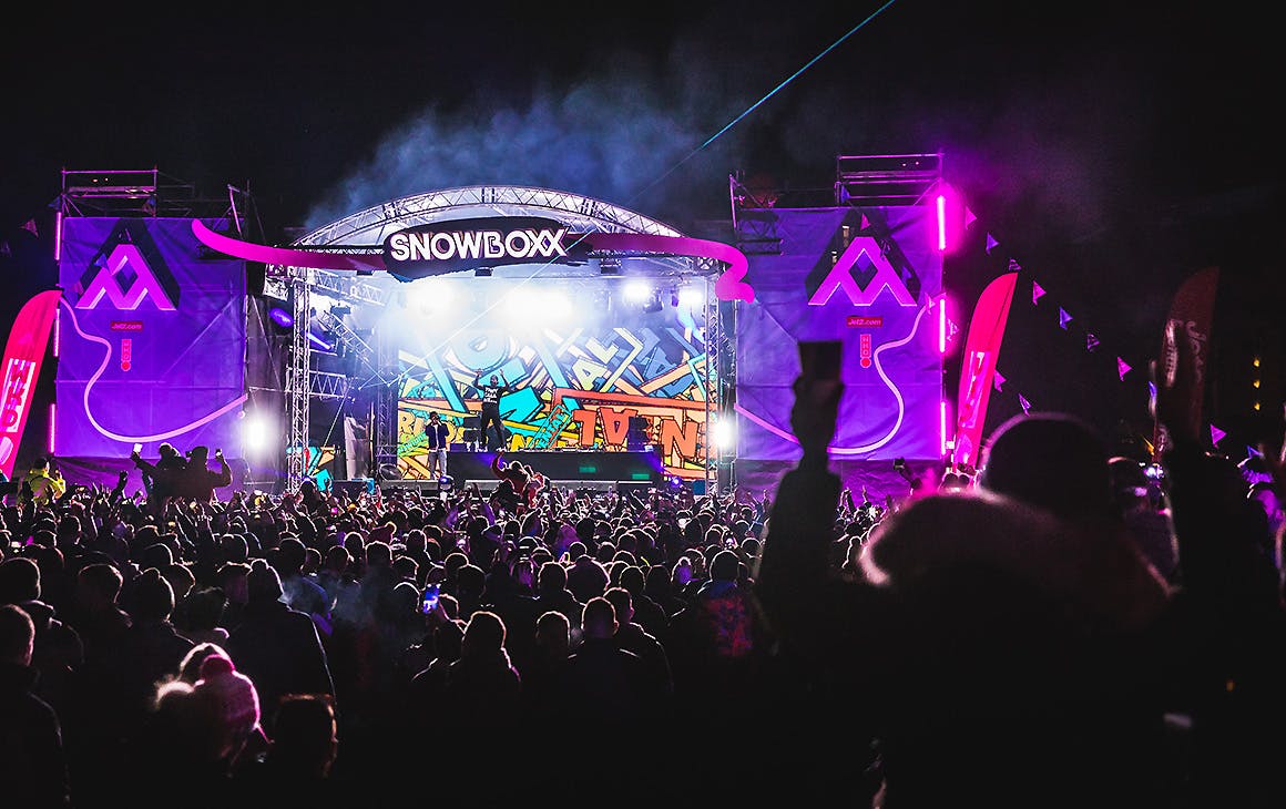 Snowboxx festival stage at night time with revellers enjoying the show.