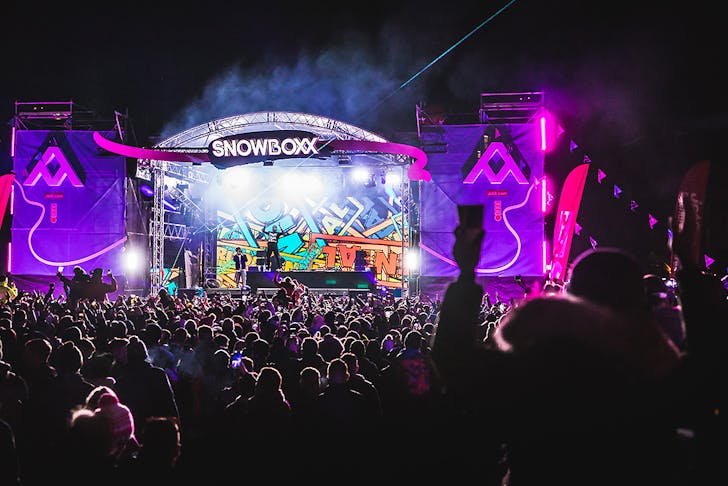 Snowboxx festival stage at night time with revellers enjoying the show.