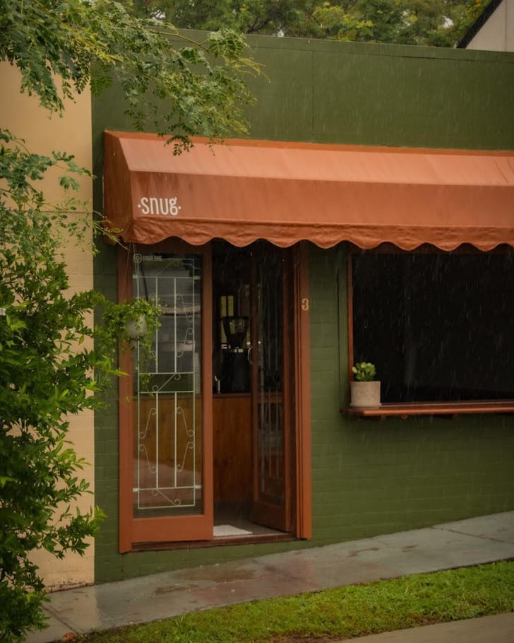 The olive-green facade of Snug cafe in Coorparoo, Brisbane.