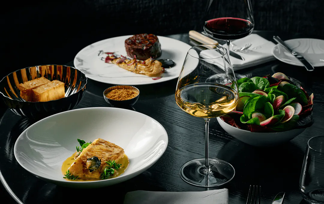A table set with different dishes including steak and sugar loaf. 