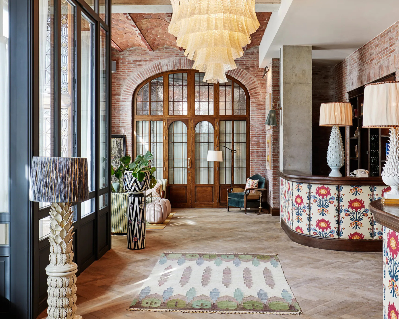 The striking entrance at Soho House Barcelona, with red-brick walls and parquet flooring.