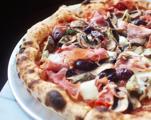 A close up of a wood fired pizza from Somedays Pizza in Noosa.
