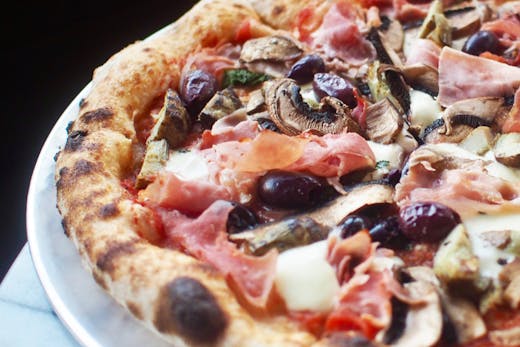 A close up of a wood fired pizza from Somedays Pizza in Noosa.