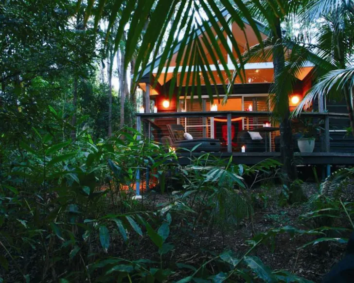 A view of a cabin surrounded by greenery at Songbirds Rainforest Retreat one of the best romantic getaways near Gold Coast