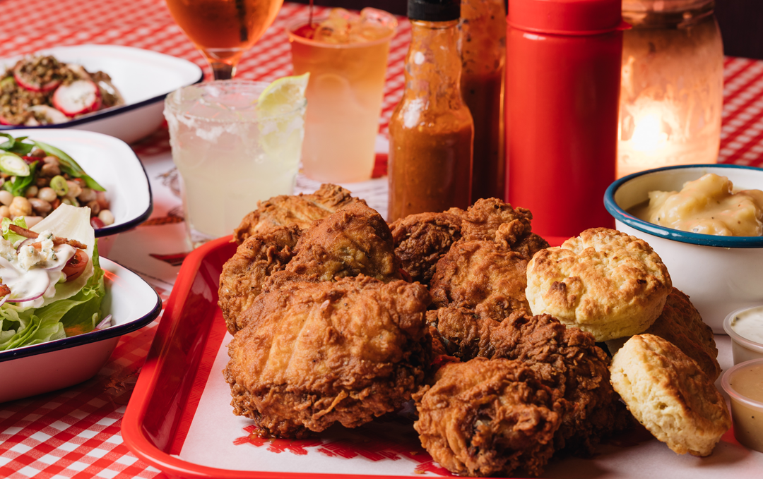 A table set with a large red tray filled with some of the best fried chicken in Melbourne.