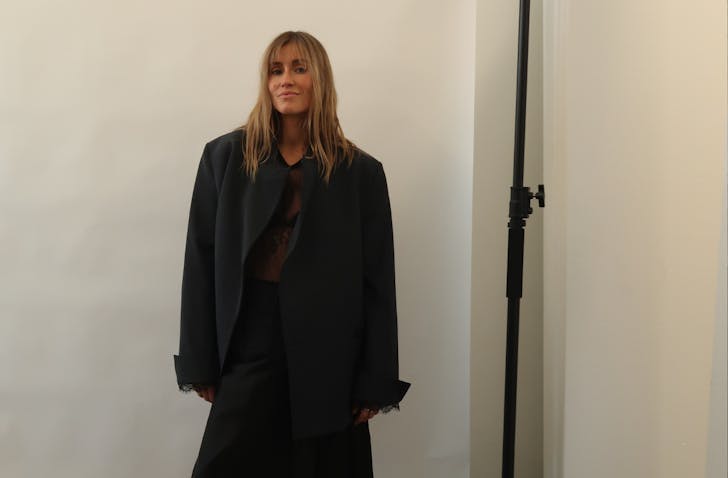 Woman standing against wall.