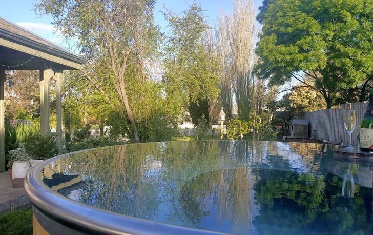 A large spa bath that overlooks the property with a backyard in Victoria.