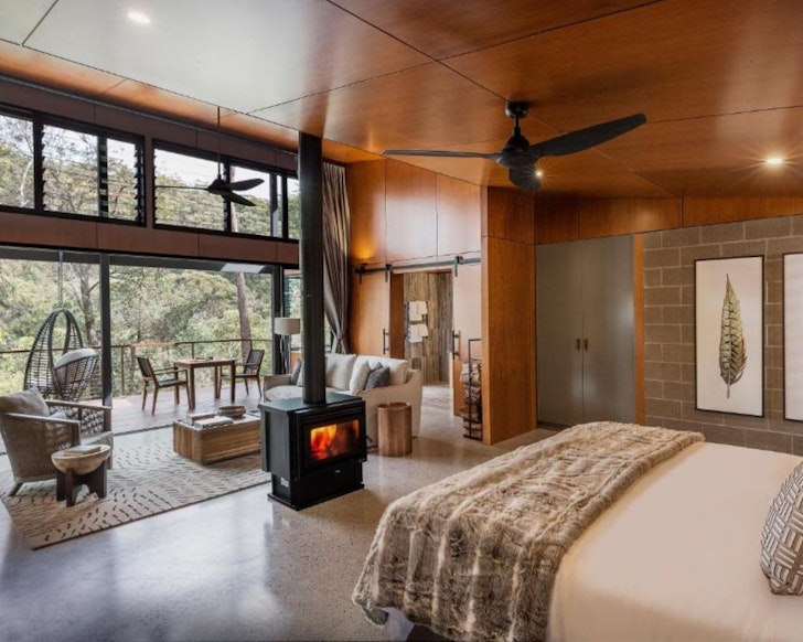 A view of a bedroom with indoor fire and egg chair at Spicers Sangoma Retreat one of the best romantic getaways in Australia