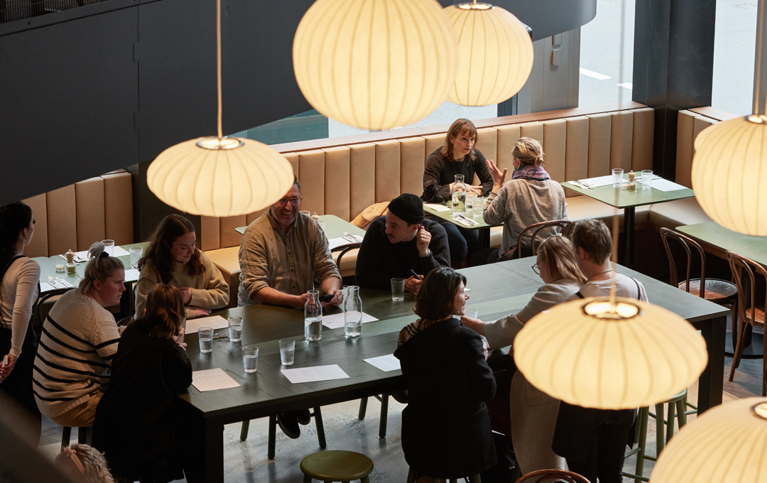 A busy dining room with hanging lights and people at tables, one of the best cafes Melbourne.