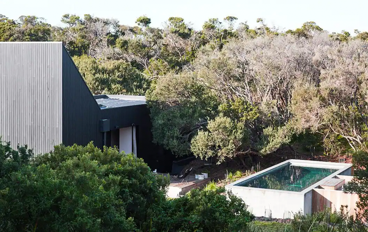A house set into the bush with a large blue pool, a top mornington peninsula accommodation.