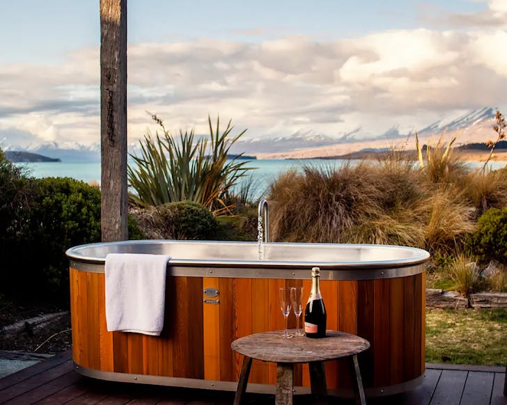 A swish modern outdoor hot tub and incredible lake view at Stargazerâs Luxury Retreat, one of the best places to stay in Lake Tekapo. 