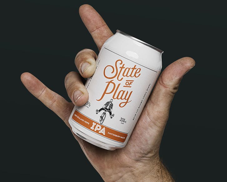 A hand holds up a can of State Of Play, one of the best non-alcoholic brews in NZ.
