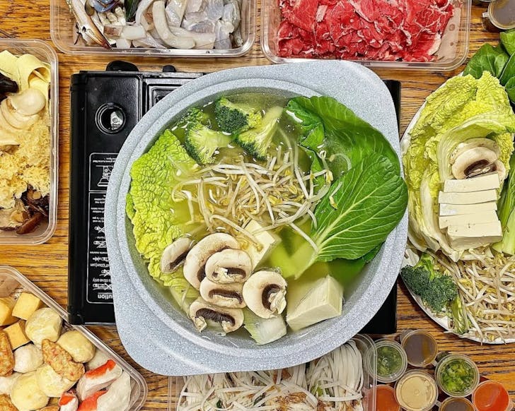 A table of meat and vegetables for hot pot.