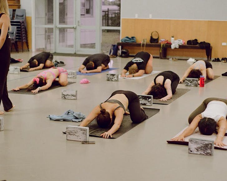 A group of people in child's pose at Bayfield School. 