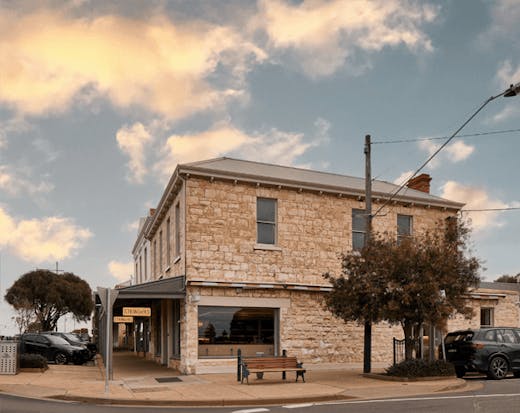A large stone building on a corner. 