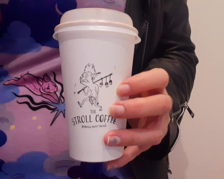 Kathryn holds a Stroll Coffee takeaway cup.