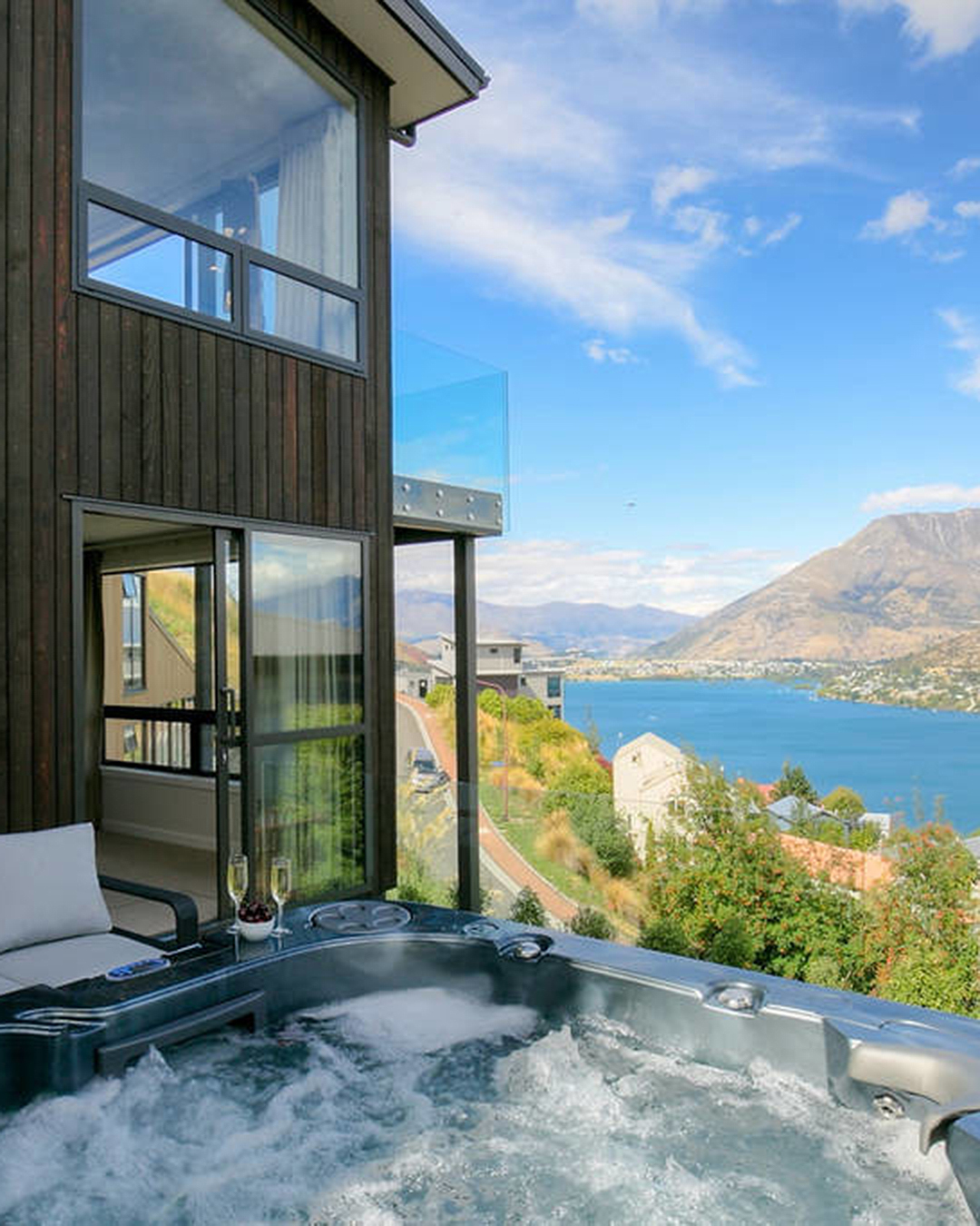 A hot tub in the foreground with a stunning Queenstown backdrop in the background.