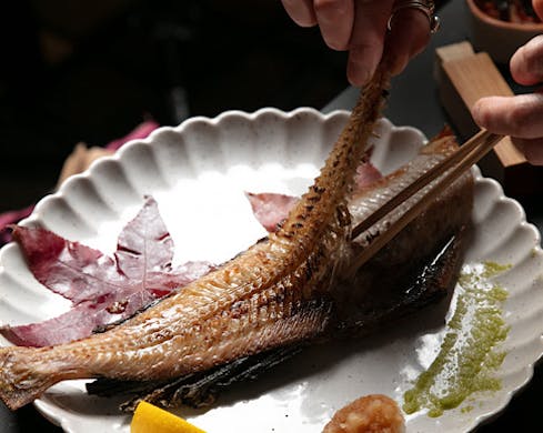 Peeling the skeleton off a half mackeral. 