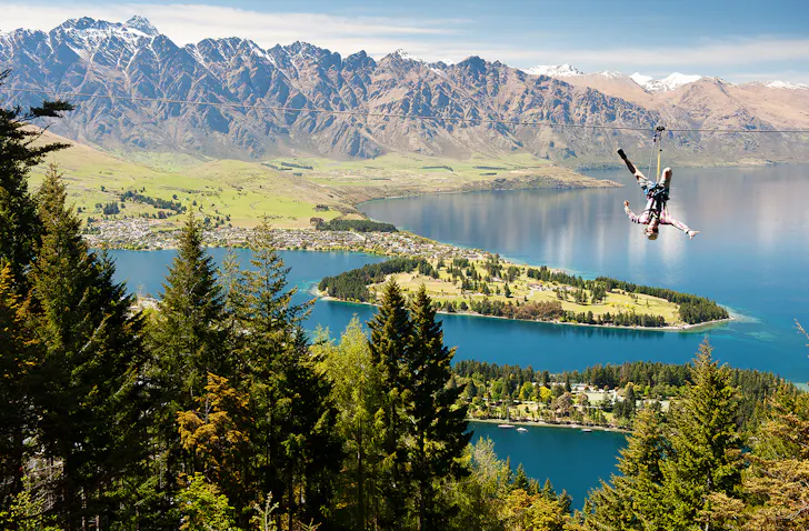 A man hanging upside down on a zip line.