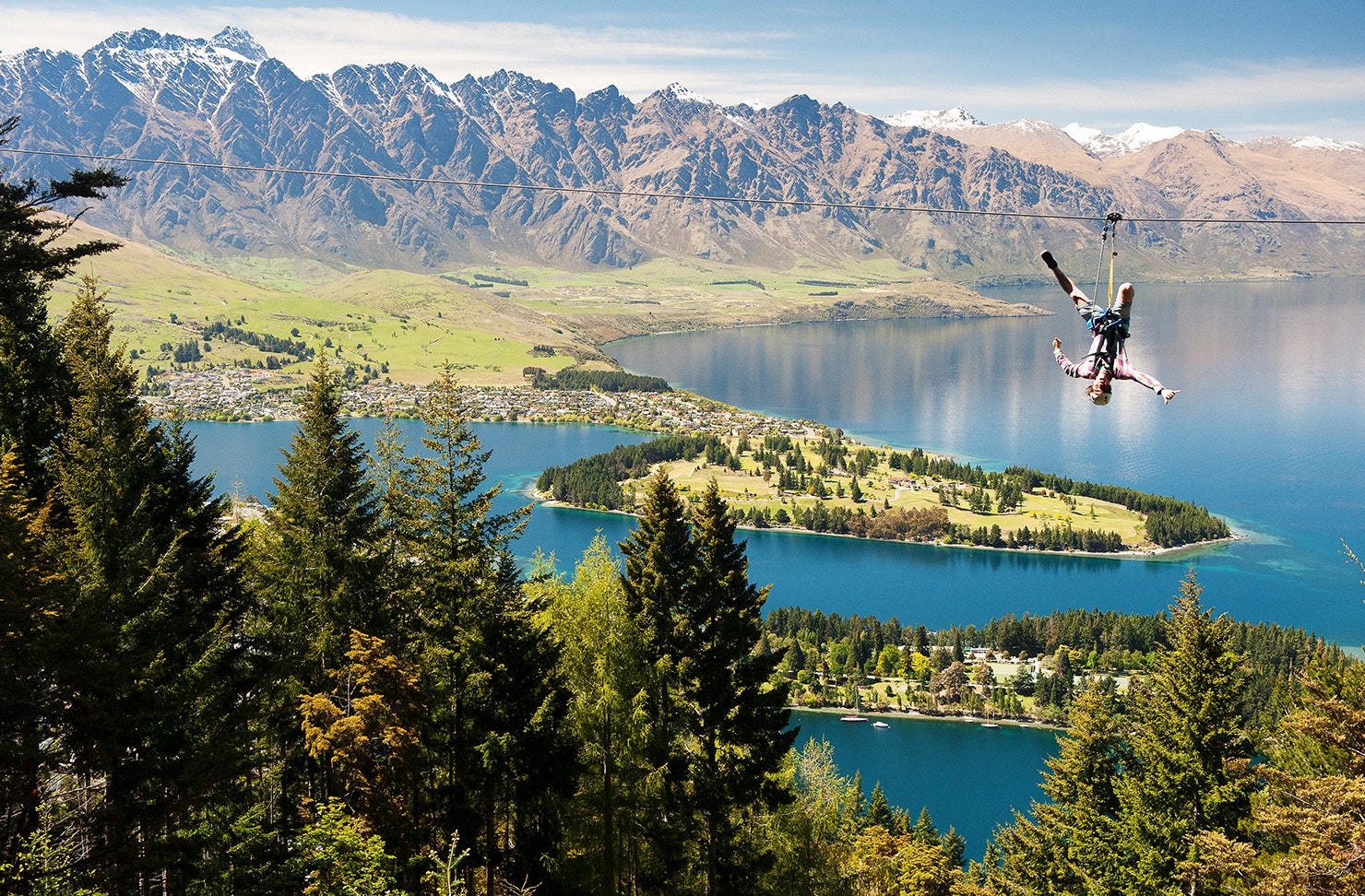 A man hanging upside down on a zip line.