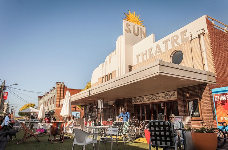 A large facade of a Victorian cinema with blue skies in the background.