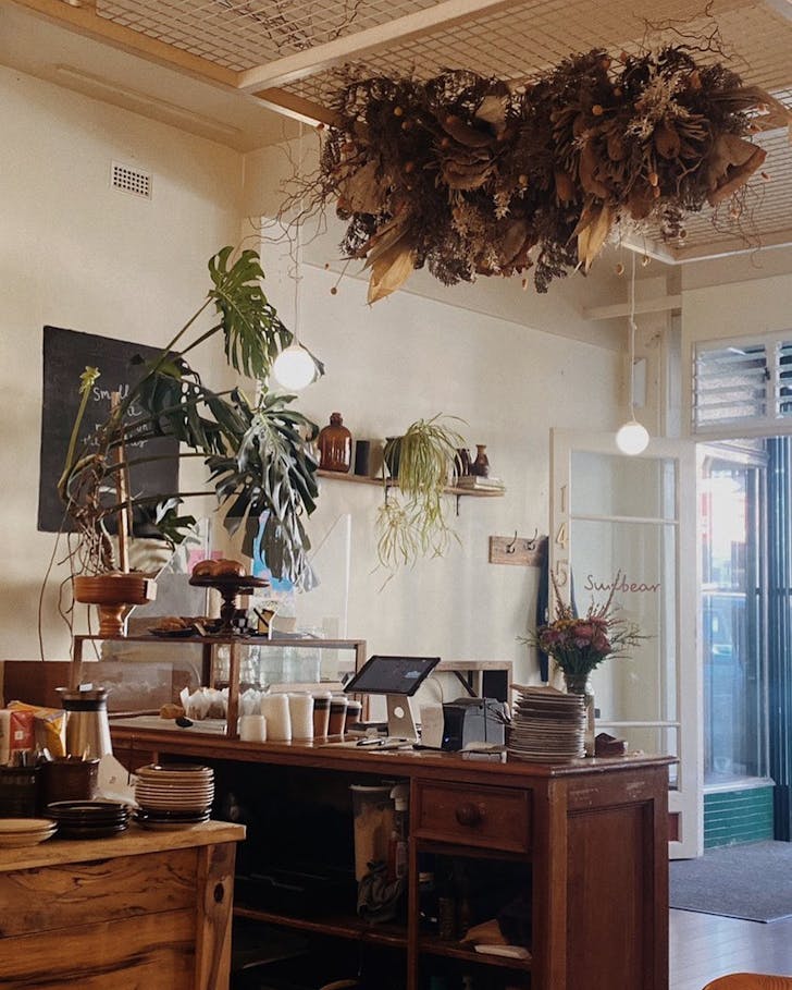 Entrance to shop with coffee and pastries on counter.