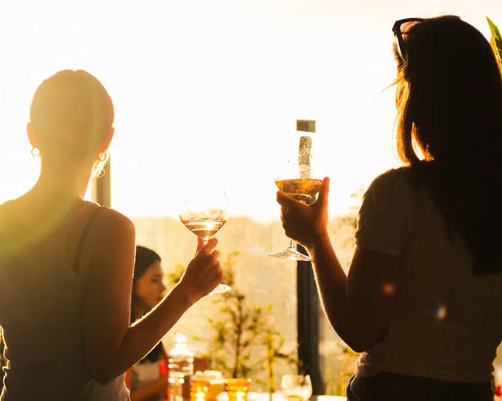 Two people, drinks in hand, enjoying the sunset at Sunset. 